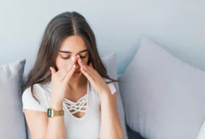 woman holding her nose because sinus pain