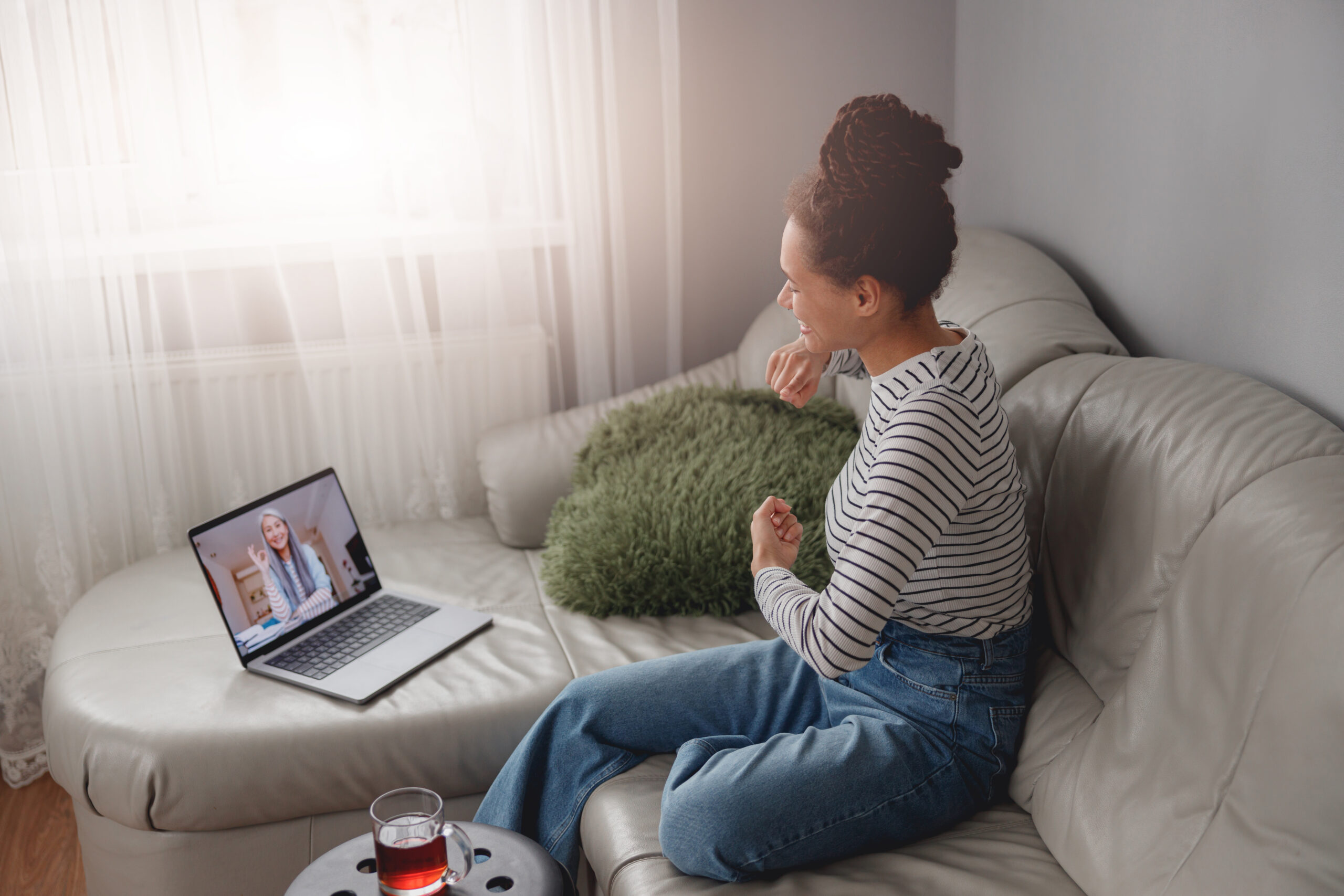 Side view of joyful smiling woman speaking on video chat online with senior female